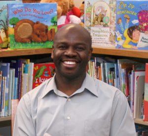 Author, Floyd Stokes, smiling sitting in library